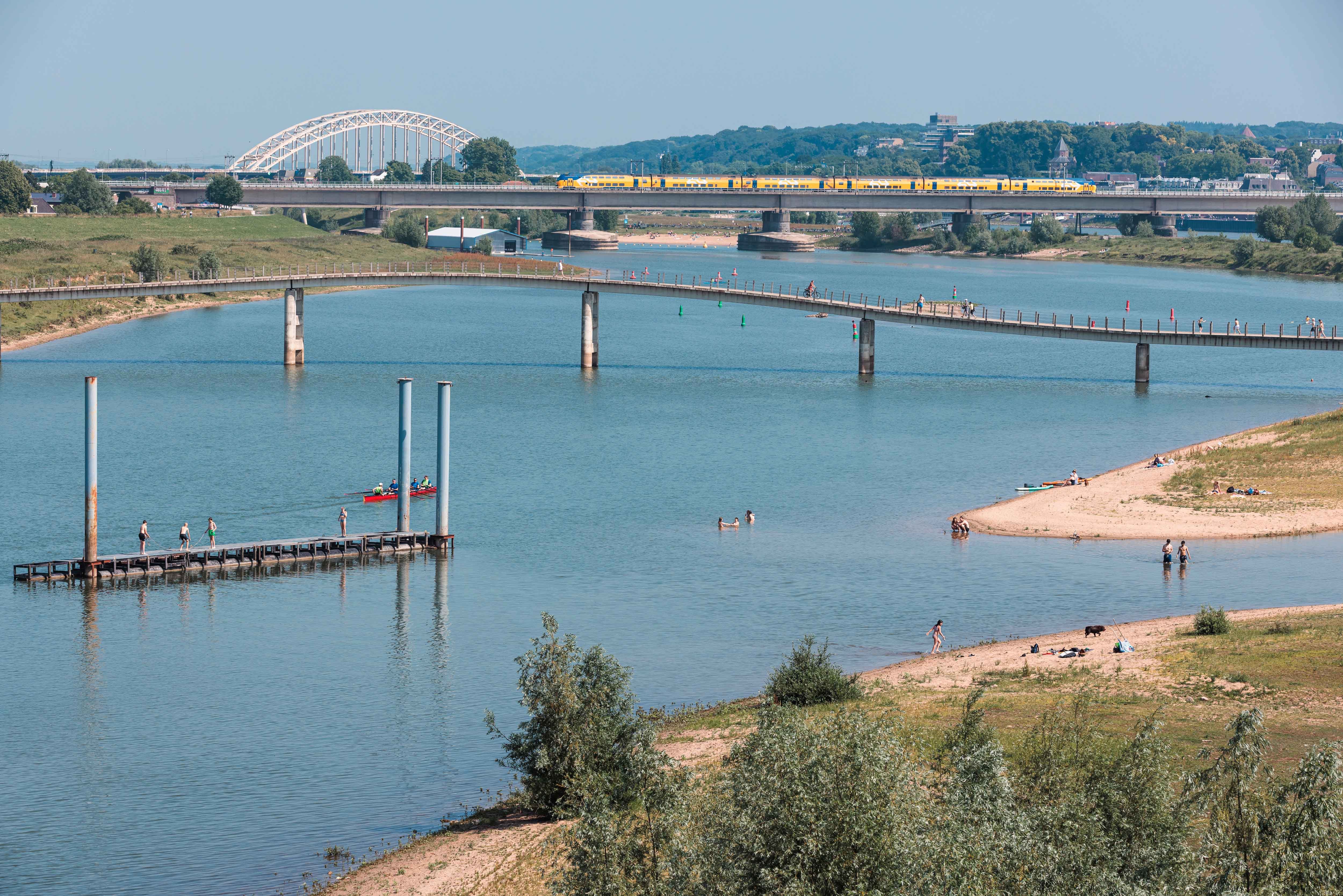 Een kanaal met een brug en een klein strandje langs de zijkanten.