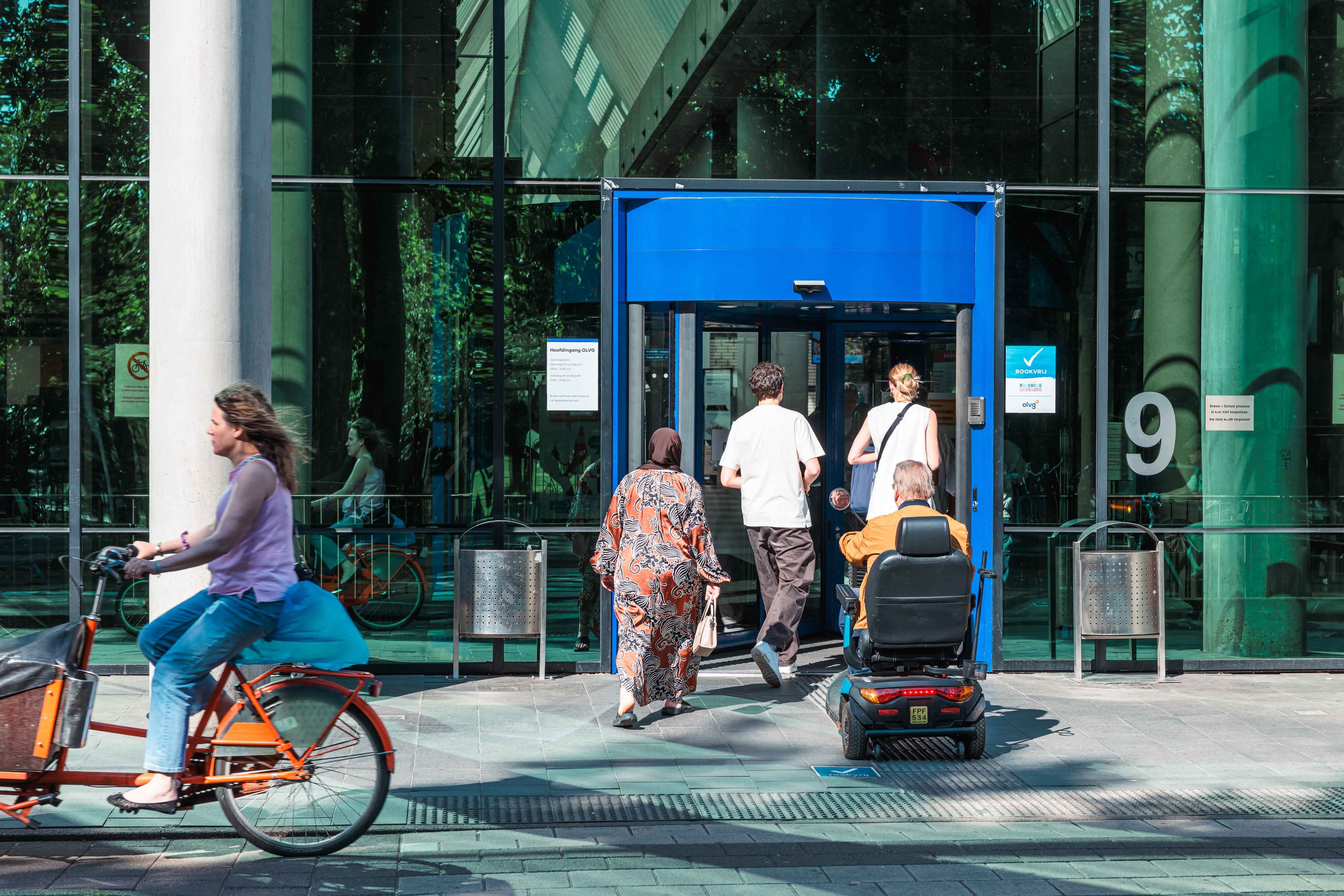 Mensen lopen de ingang van het OLVG-ziekenhuis binnen.