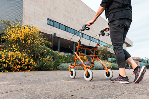 Persoon met rollator voor zorginstelling