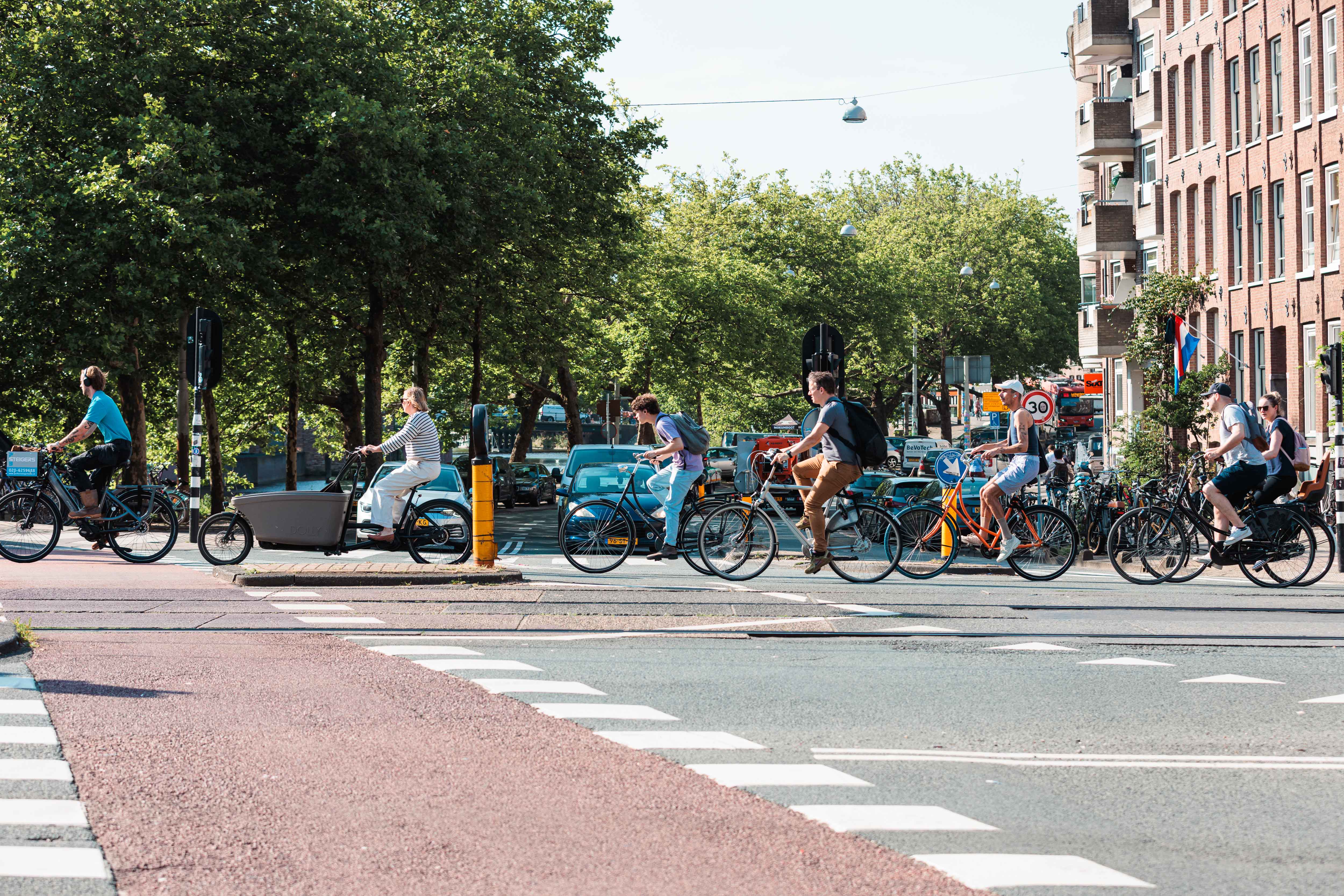 Een groep fietsers rijdt achter elkaar door de stad.